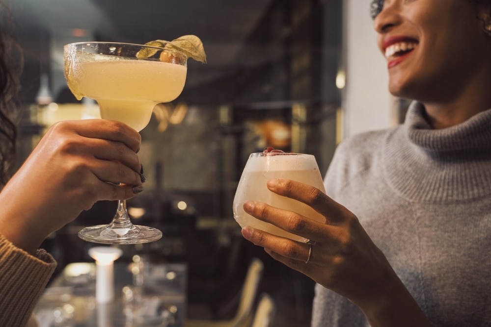 Two people sharing a margarita at the top Santa Fe Restaurants in 2023