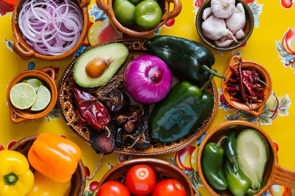 New Mexican food cooking ingredients include Hatch chiles, onions, tomatoes, and peppers.