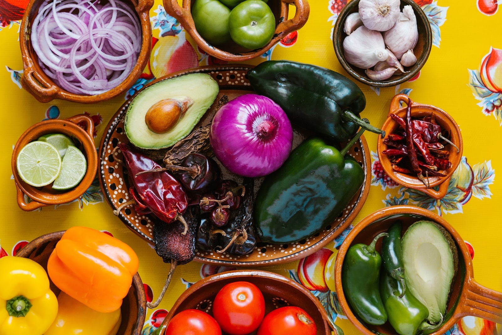 New Mexican food cooking ingredients include Hatch chiles, onions, tomatoes, and peppers.