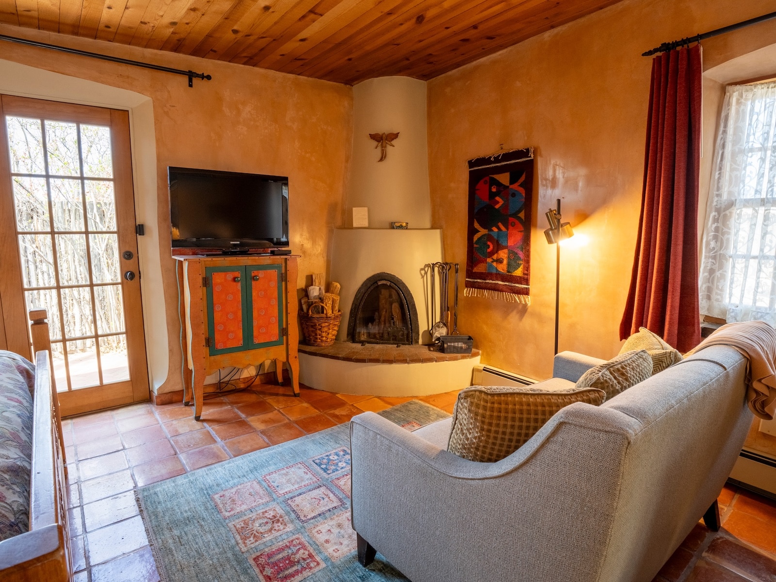 A Room With A Couch, Fireplace, And Tv, Showcasing New Mexico Art And And Style At A Santa Fe Bed And Breakfast.